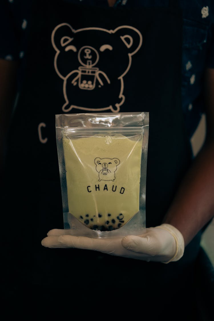 A Pack Of Delicious Milk Tea With Black Pearls On A Person's Hand