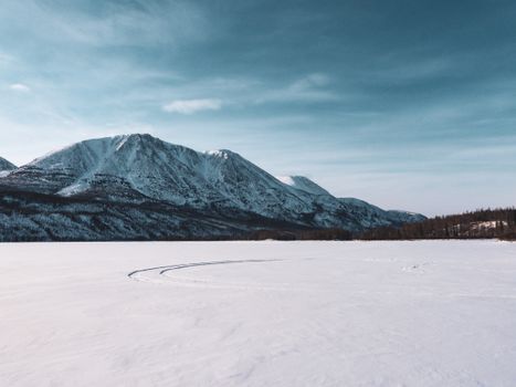 Serene winter mountain landscape with snow and clear blue sky.