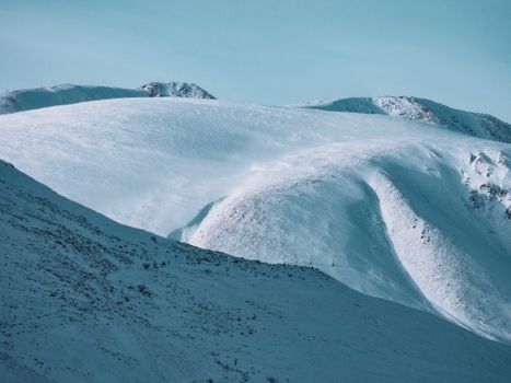 Breathtaking view of snow-covered mountains under a clear blue sky.