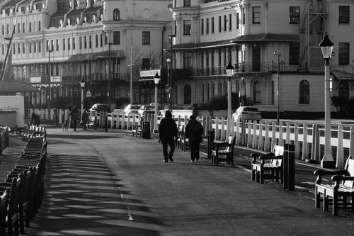 Free Monochrome street view with people walking along a lined sidewalk. Stock Photo