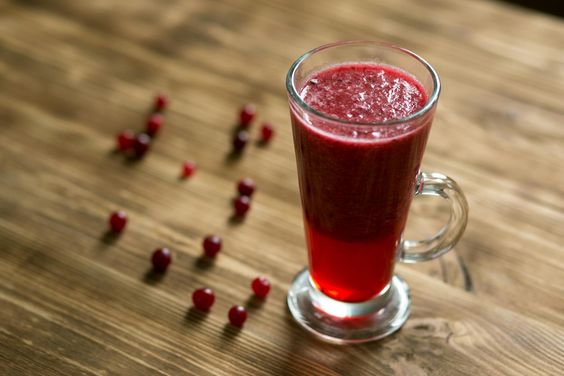 Glass Mug With Red Juice on Wooden Table