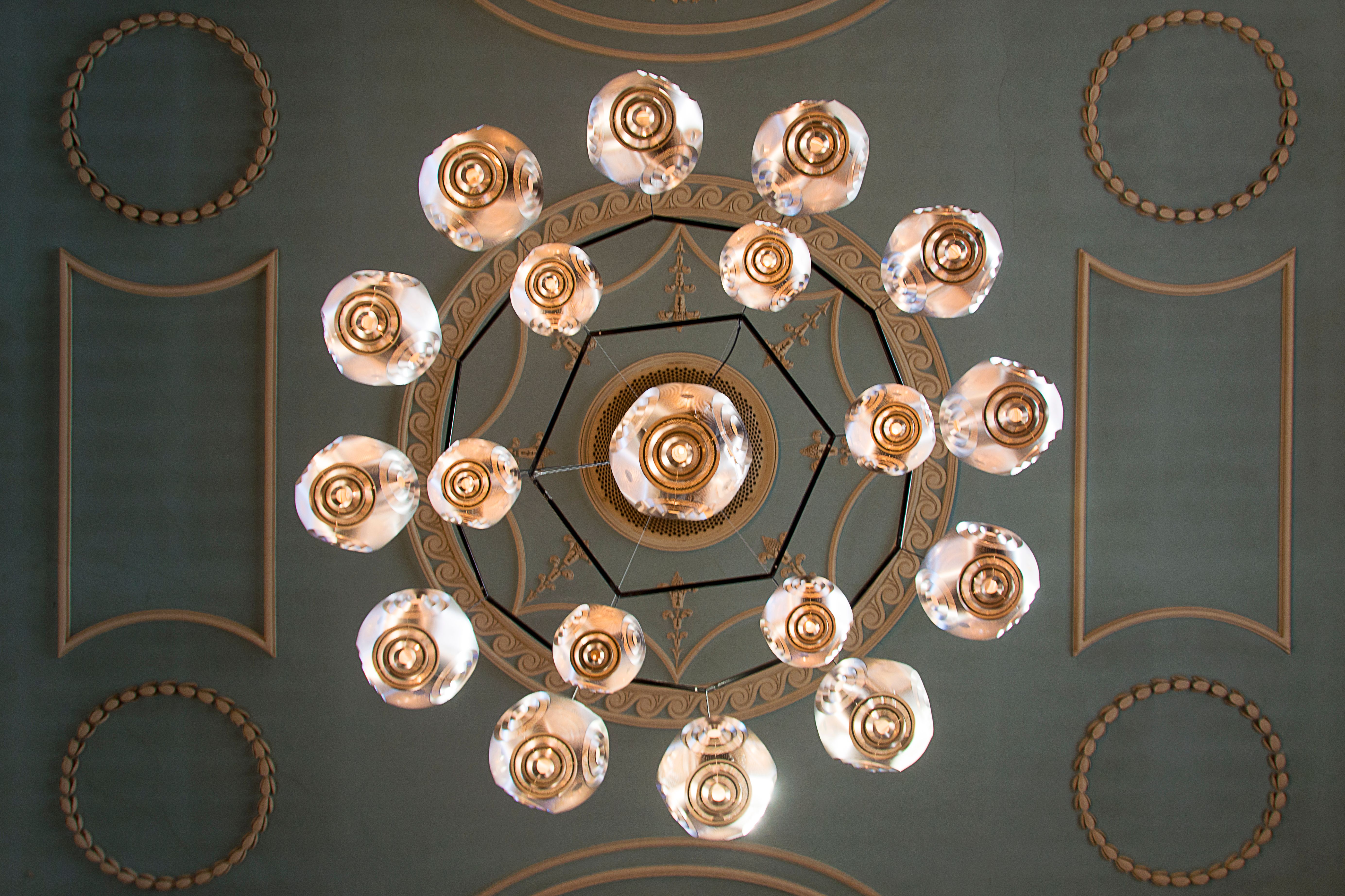 A top-down view of an intricate chandelier and ornate ceiling design, showcasing classic elegance.