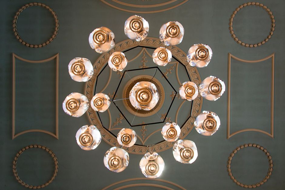A top-down view of an intricate chandelier and ornate ceiling design, showcasing classic elegance.