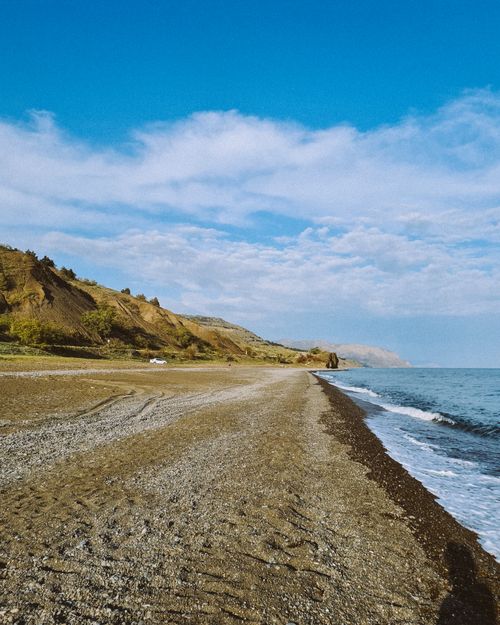 Free Serene beach with clear blue skies and gentle sea waves, perfect for a peaceful getaway. Stock Photo