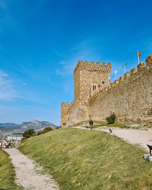 Free Scenic view of a medieval castle with a clear sky, offering historical allure. Stock Photo