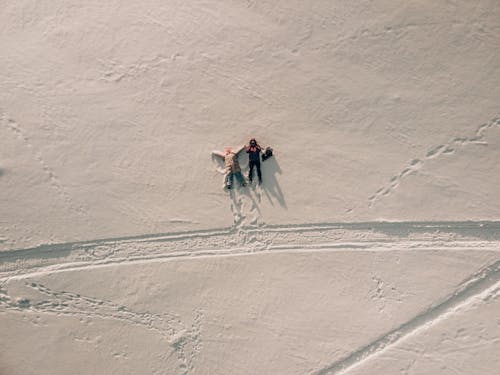 An Aerial Shot of People Lying Down on Snow