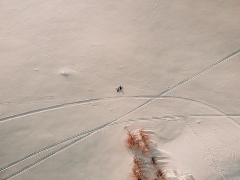 Drone shot capturing a vast snow-covered field in Novosibirsk with visible ski tracks and minimal vegetation.