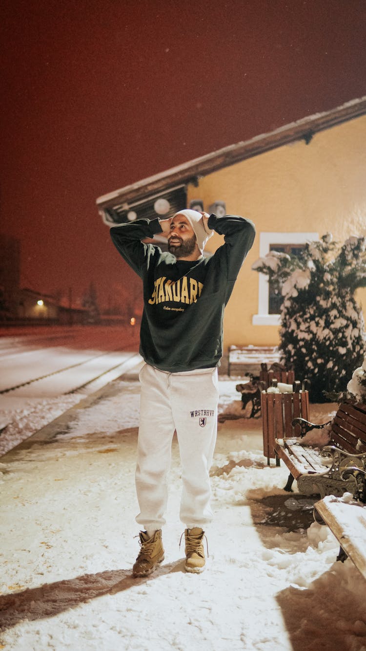 Man On Sidewalk In Snow At Night