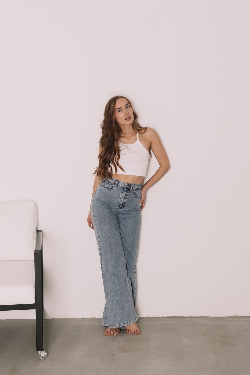 Woman with Long Wavy Hair Posing in Blue Jeans · Free Stock Photo