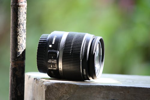 Black Canon Lens on Gray Concrete Table