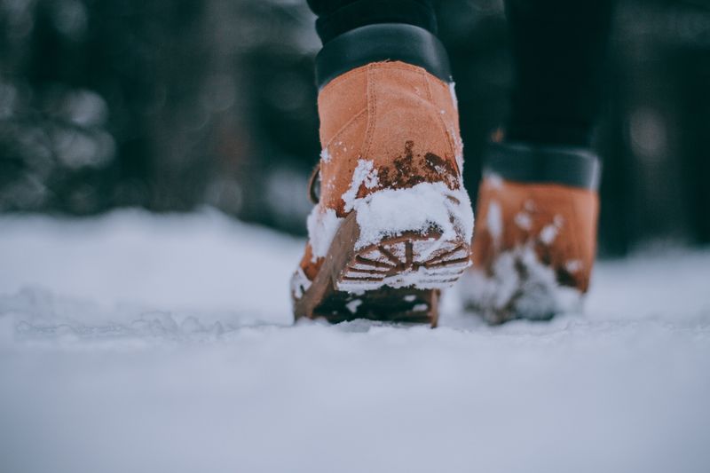 Close-up of boots walking in snow
