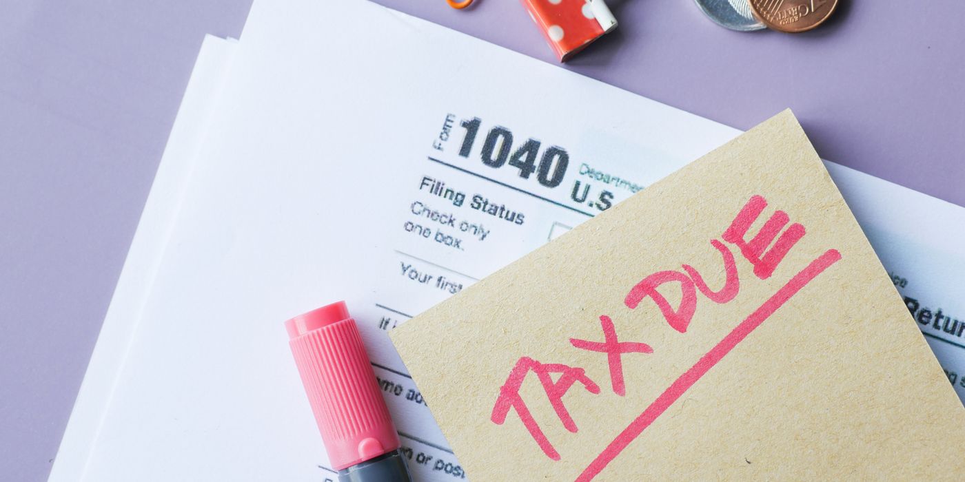 Close-up of IRS Form 1040 with 'Tax Due' note and stationery on a desk.