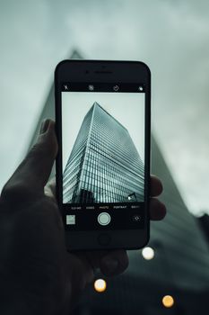 A smartphone captures a skyscraper in London. Modern technology meets architecture.