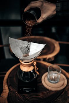 Aesthetic image of ground coffee being poured into a filter for the perfect brew.