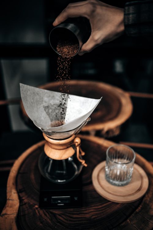 Free Aesthetic image of ground coffee being poured into a filter for the perfect brew. Stock Photo