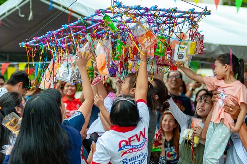 Free Joyful gathering of people enjoying the traditional Pabitin game at an outdoor festival. Stock Photo