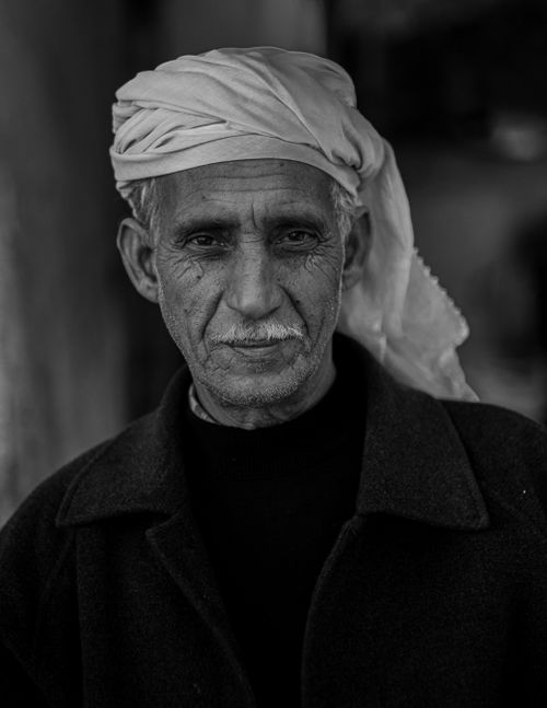 Free Expressive black and white portrait of a senior man wearing a headscarf and displaying wisdom. Stock Photo