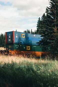 Colorful shipping containers in a serene Canadian rural setting, surrounded by nature.