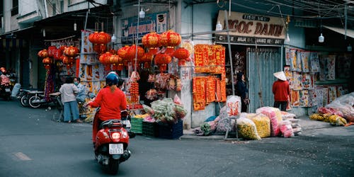 A Person Riding a Red Motor Scooter on the Road