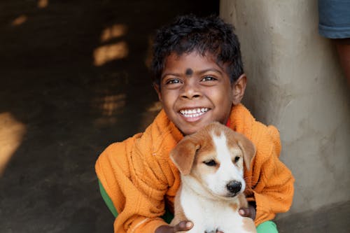 Photograph of a Boy Holding a Puppy