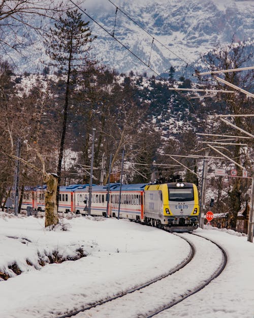 A Yellow and Blue Train on Snow Covered Railroad