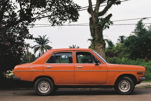 Classic orange vintage car parked on a side street in Kluang, Malaysia.