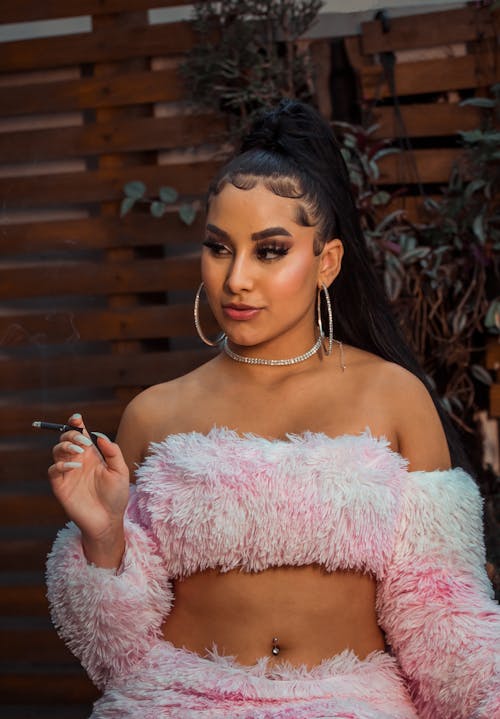 Woman in Pink Fur Tube Top Holding a Cigarette