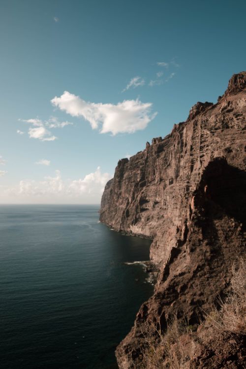 Free Majestic cliff with deep blue ocean view under a clear sky, creating a breathtaking coastal landscape. Stock Photo