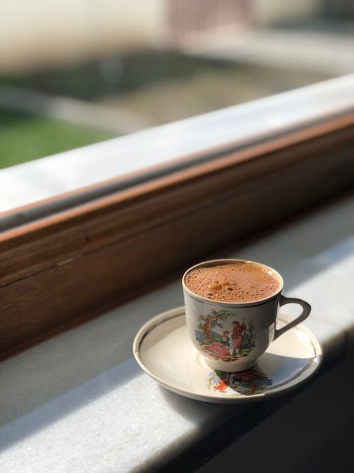 Free A classic Turkish coffee cup on a saucer by a sunlit window sill in Balıkesir, Turkey. Stock Photo