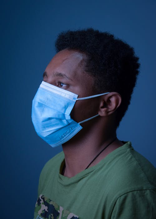 A Man in Green Crew Neck Shirt Wearing Surgical Face Mask