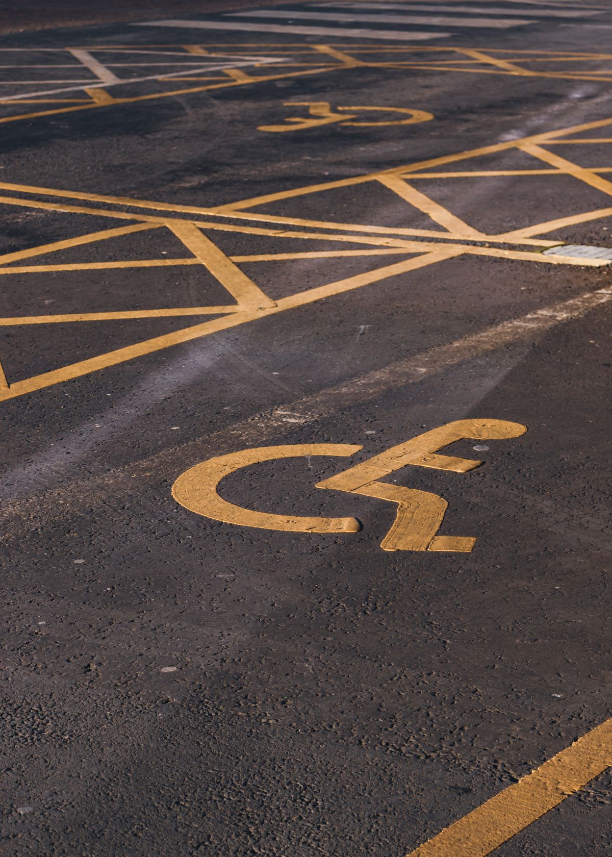 Close-up of an accessible parking bay marked with a wheelchair symbol on the tarmac
