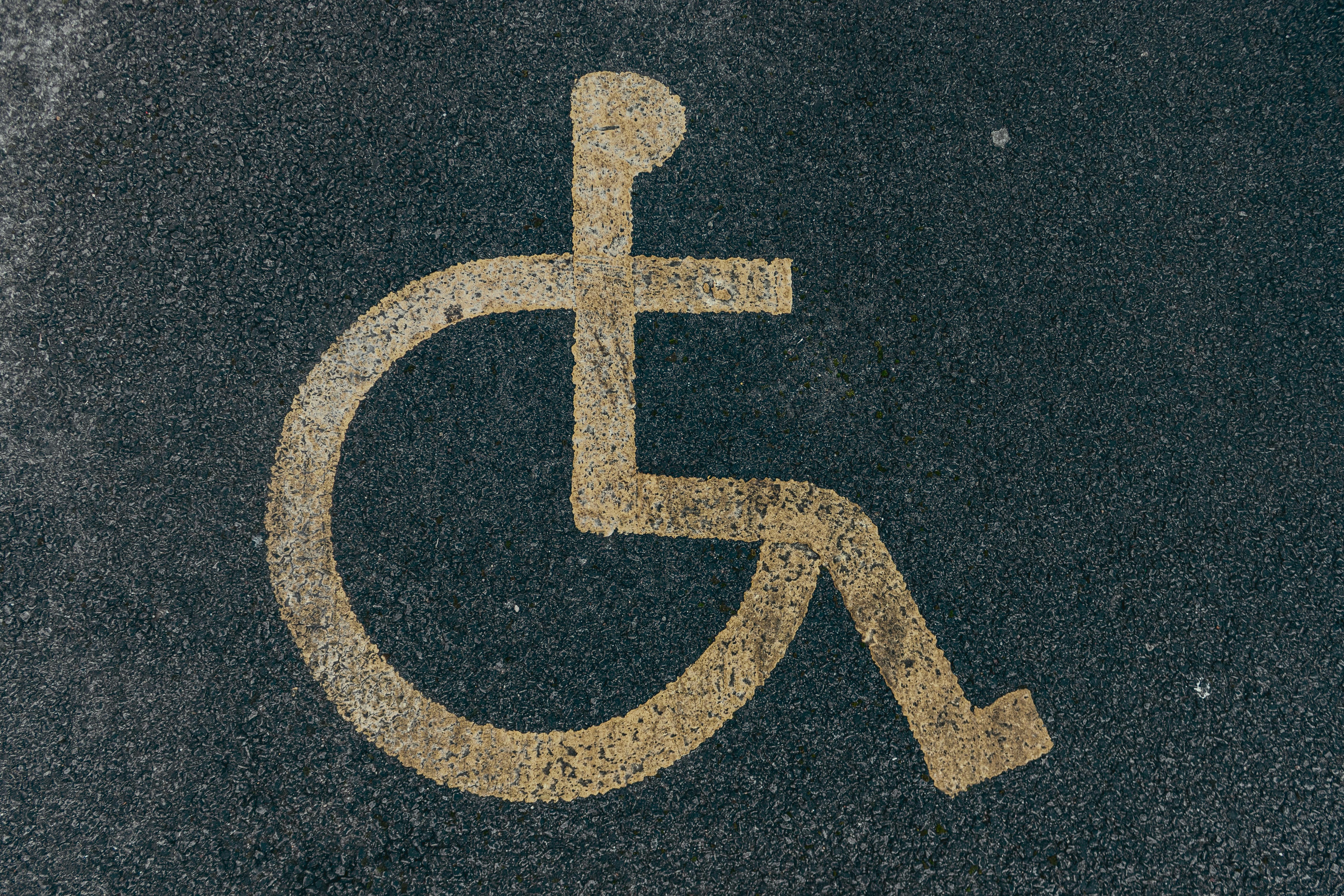 painted disability icon on asphalt pavement