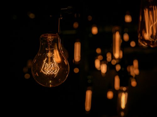 Free Warm glow of vintage light bulbs hanging in a dark setting, creating an inviting atmosphere. Stock Photo