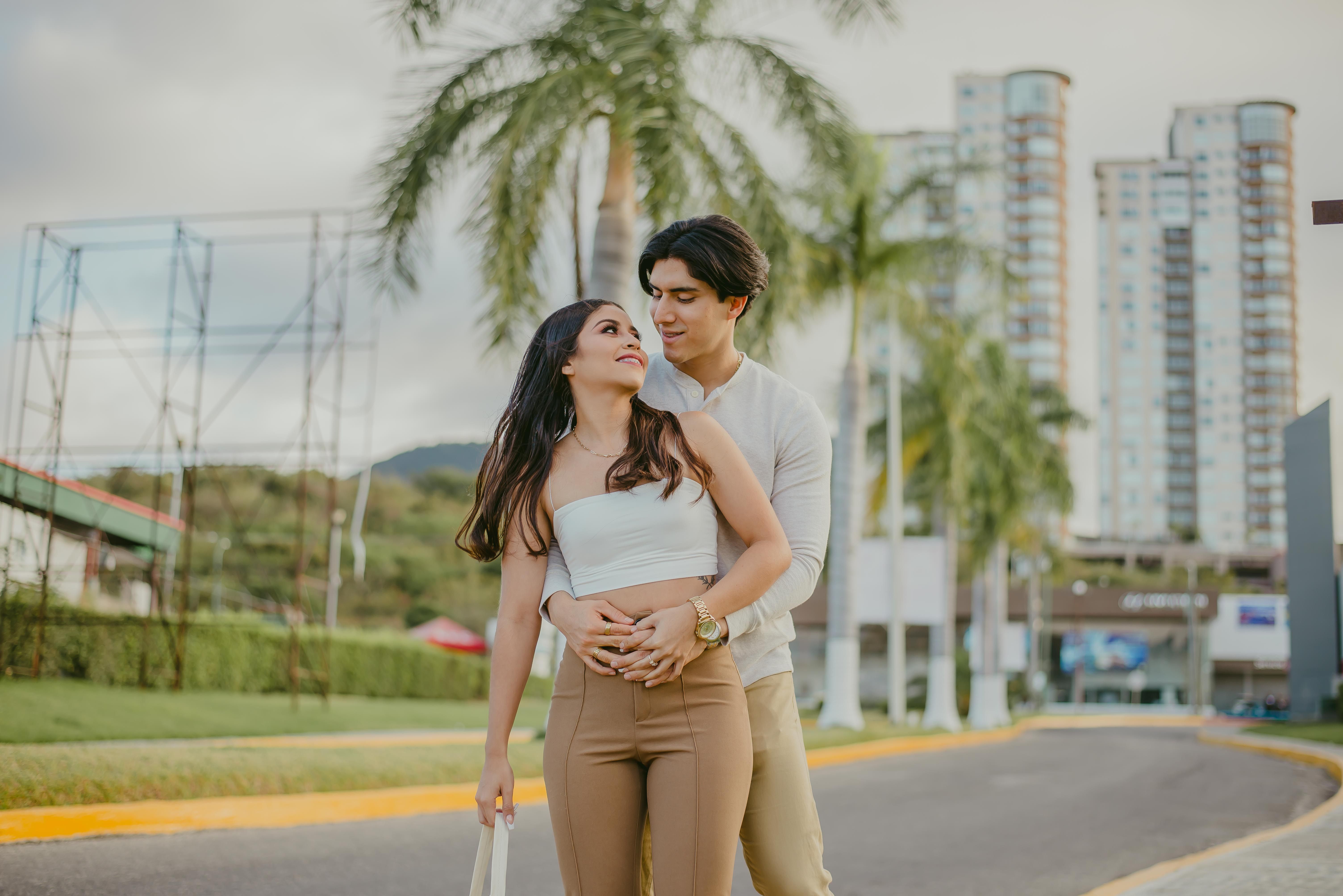 Young couple embracing in an urban setting, conveying love and joy against a city backdrop.