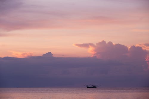 Silhouette of Ship on Sea during Sunset