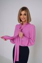 Woman in Pink Blouse Smiling and Holding Shawl Collar in Hands