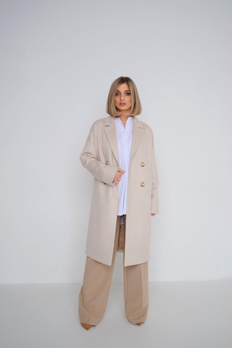 Blond Female Model Standing Barefoot In Classic Beige Business Outfit