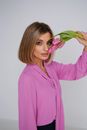 Woman in Pink Shirt Touching Her Face with Pink Flowers