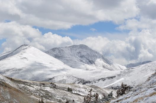 Stunning view of snow-covered mountains under a cloudy sky in the Colorado Rockies.