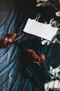 白色背心、牛仔裤和凉鞋，搭配花卉床罩，打造休闲装扮