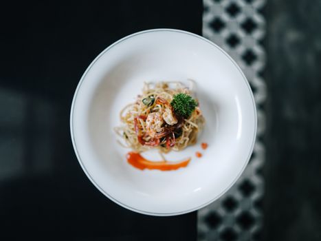 Elegant shrimp pasta served in a minimalist presentation on a white plate.