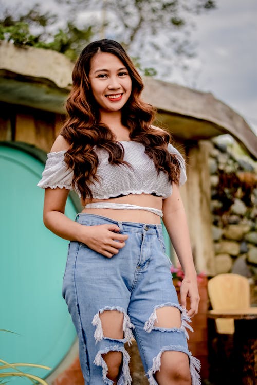 Woman in White Crop Top and Ripped Jeans Smiling