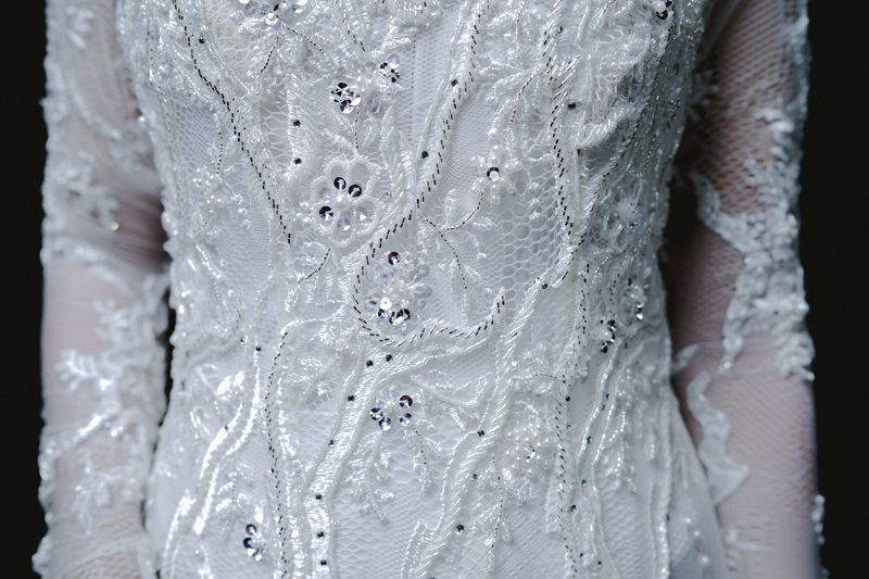 Detail gaun pengantin lace dengan sulaman dan manik yang elegan.