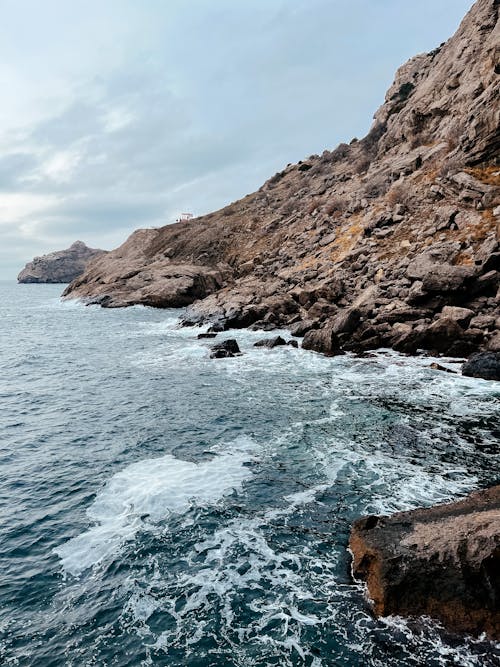 Brown Rock Formation Beside Body of Water