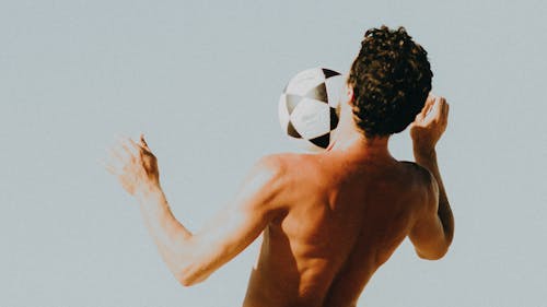 Topless Man Receiving Soccer Ball on His Chest