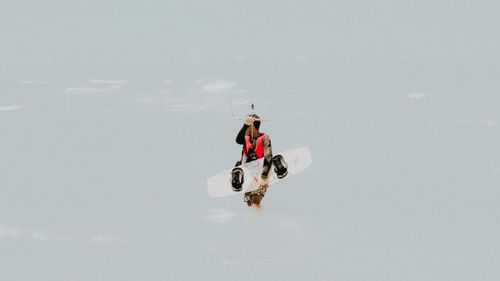 Free A kitesurfer holding equipment wades through the sea in Canoa Quebrada, Brazil. Stock Photo