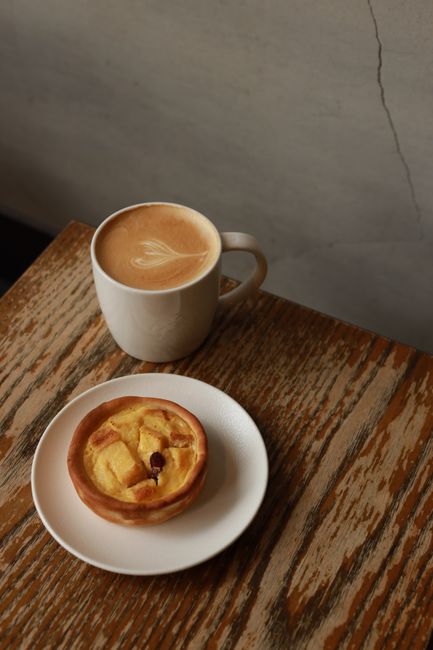 Warm cappuccino with heart design and pastry on a wooden table in Taiwan.
