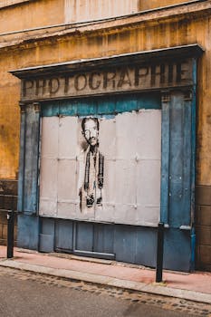 A vintage photography storefront with iconic street art in Toulouse, France.