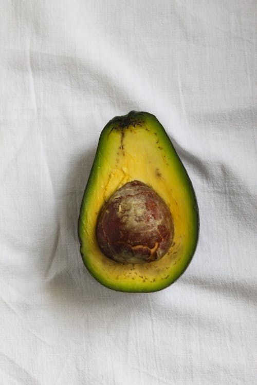 A Sliced of Avocado on a White Surface