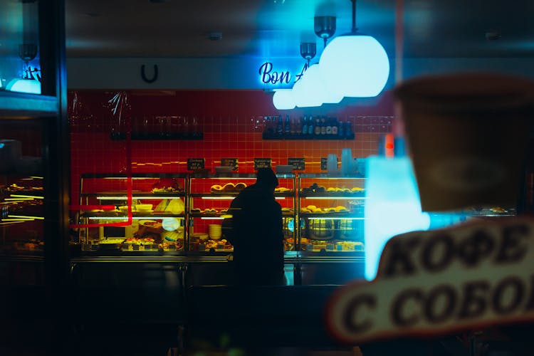 Silhouette Of Person In Bakery At Night